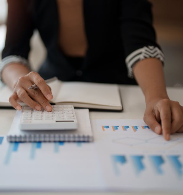 Kobieta prowadzi obliczenia na kalkulatorze i sprawdza statystyki ekspert kredytowy